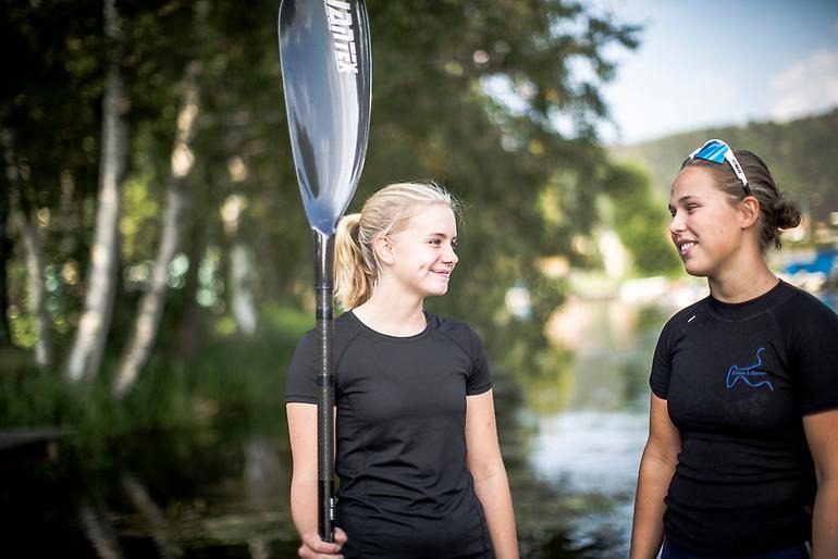 Två unga kanotister småpratar med varandra.